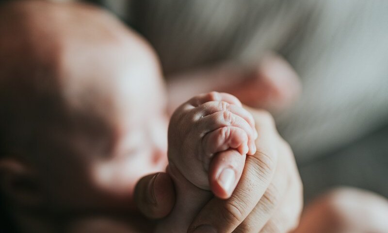 person holding babys feet