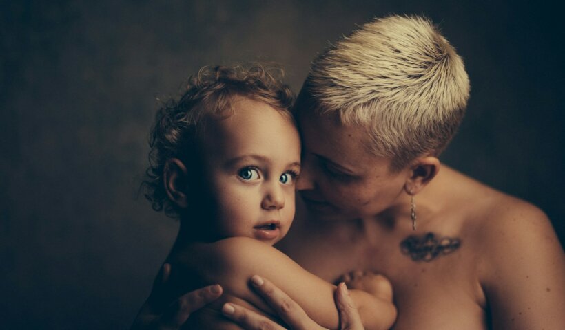 topless woman holding baby